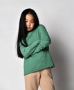 Asian kid girl green sportswear pants and hoodie, sweater stands holding arms crossed at chest Royalty Free Stock Photo