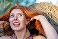 Sensual, seductive portrait of happy, laughing beautiful red-haired redhead woman with freckles, outdoors, playing with her long Royalty Free Stock Photo