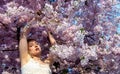 sensual seductive young sexy blonde woman portrait in white dress surrounded by delicate soft pink japanese cherry flower blossoms Royalty Free Stock Photo