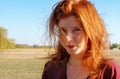 Sensual sexy portrait of young beautiful mischievous smiling redhead girl, outdoors in the summer sunlight