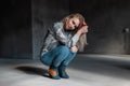 Sensual sexy young blonde woman in vintage cowboy boots in summer shirt in fashionable ripped jeans sit in a room with sunlight.