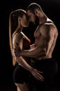 Sensual sporty couple embracing isolated on black