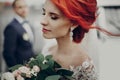 Sensual stylish bride holding modern bouquet and relaxing with windy hair and groom looking at her near retro car. luxury wedding Royalty Free Stock Photo