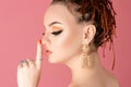 Sensual woman with bright makeup with silence gesture