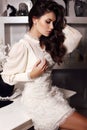 Sensual woman with long dark hair wears elegant dress,posing at bedroom Royalty Free Stock Photo