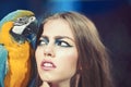 Sensual woman look at parrot. Woman with blue and yellow macaw. girl with makeup and bird pet. Beauty model with Royalty Free Stock Photo