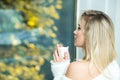Sensual woman with morning coffee. Girl drinking coffee or tea in morning sunlight. Close up lifestyle portrait of woman Royalty Free Stock Photo
