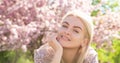 Sensual woman near sakura tree background, banner for website header. Happy girl with flowers in grass. Cute face of