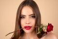 Sensual woman with red lips with red rose, beige background.