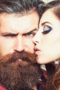 Sensual woman kiss bearded man, love. Woman with makeup skin and hipster with long beard. Couple in love and family
