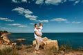 Sensual young couple in glasses in love jump on the rock in the sea near the beach with big cliffs. Man and woman looking on each Royalty Free Stock Photo