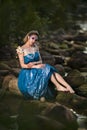 Sensual Young Mermaid of Sea in Artistic Caucasian Blond Woman With Strasses on Face Sitting in Blue Wet Dress on Rocky Shore Royalty Free Stock Photo