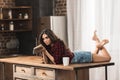 sensual young woman with book lying on table with cup