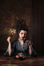 Sensual young woman in a geisha asian costume with fashion makeup and hair style drinks tea and eats sushi