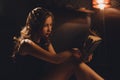 Sensual young woman sitting in a black lingerie and looking in a book Royalty Free Stock Photo