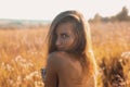 Sensual young woman with naked back standing in a beautiful summer field Royalty Free Stock Photo