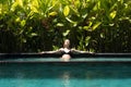 Sensual young woman relaxing in outdoor spa infinity swimming pool surrounded with lush tropical greenery of Ubud, Bali. Royalty Free Stock Photo