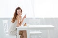 sensual young woman sitting at table with strawberry pancakes