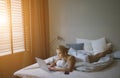 Sensual young woman in white tank top and panties lying on bed near laptop Royalty Free Stock Photo