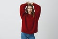 Sensuality, beauty, cosmetology concept. Portrait of attractive self-assured slim young woman in red loose cozy sweater Royalty Free Stock Photo