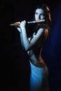 Sensuality brunette plays a wooden flute Royalty Free Stock Photo