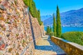 The stone alley with cypress trees and Lake Lugano in background, Morcote, Switzerland Royalty Free Stock Photo