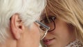 Sentimental forehead touch of young and senior woman. Close up