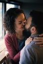 Sentimental happy couple in love near a window in a cafe