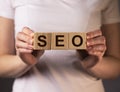 SEO acronym word on ooden cubes in hands