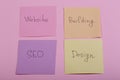 seo concept - colorful sticky notes with words design, website, seo, building on pink background