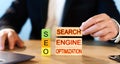 SEO concept, man stacks wooden blocks with the words Search Engine Optimization. Royalty Free Stock Photo