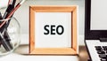 SEO - Search engine optimisation. Text in wooden frame on office table Royalty Free Stock Photo