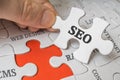SEO Search engine optimization concept. Man is solving puzzle