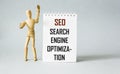 SEO search engine optimization text is written on a notepad and on a blue background. Royalty Free Stock Photo