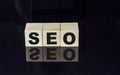 SEO text on wooden cubes on black background