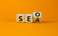 SEO vs SEA. Turned a cube and changed the word `SEA - search engine advertising` to `SEO - search engine optimization`. Busine Royalty Free Stock Photo