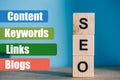SEO word made from wooden blocks on blue background with Content Keywords Links