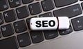 SEO - the word on a white flash drive, lying on a black laptop keyboard