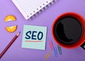 SEO wrriten on notepad Closeup with Cup of Tea Royalty Free Stock Photo