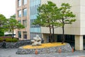 Small architectural forms. Stone abstraction and green pine trees.