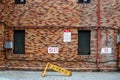 Seoul, South Korea - Broken yellow barricade and `No Smoking` sign and a red pipe on a brick wall