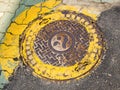 Seoul, South Korea - June 26, 2017: Round yellow sewer hatch on the street in Seoul downtown.