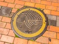 Seoul, South Korea - June 26, 2017: Round yellow sewer hatch on the street in Seoul downtown.