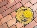 Seoul, South Korea - June 26, 2017: Yellow sewer hatch on the street in Seoul downtown.