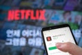 Seoul, south Korea - May 20, 2020: Hands to install the app with the Netflix screen and smartphone of the television