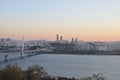 SEOUL, SOUTH KOREA - OCTOBER 24, 2022: Calm Sunset scene with bridge, buildings, and Han river in the afternoon and vanilla sky