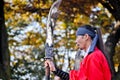 SEOUL, SOUTH KOREA - OCTOBER 23, 2022 Traditional Korean Kingdom Soldier Warrior stands with long lance among Autumn foliage