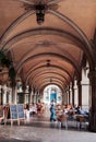 Street restaurant dinner table under arch arcade with sunlight i Royalty Free Stock Photo