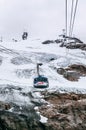 Rotair Gondola lift flying over alpine rock mountain cliff of Titlis in Engelberg, Switzerland