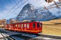 Jungfrau railway train at Kleine Scheidegg station with Eiger and Monch peak Royalty Free Stock Photo